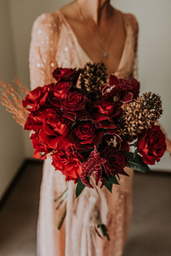 a refined fall wedding bouquet of burgundy roses, orchids, some dried flowers and amaranthus is adorable