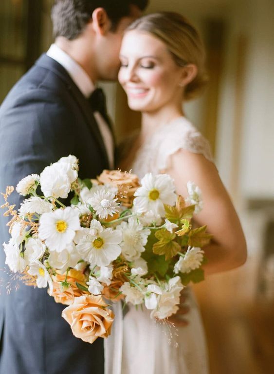 a refined wedding bouquet of peachy roses, white cosmos and other blooms is a stylish idea for summer