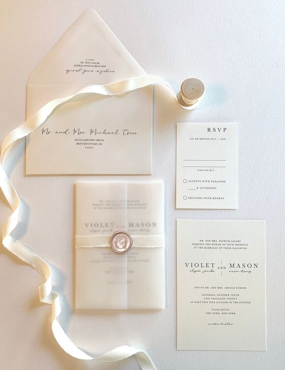 a refined wedding invitation suite with a vellum envelope and black lettering and calligraphy is chic