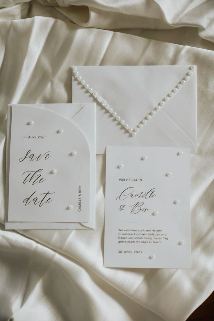 a refined white wedding invitation suite with calligraphy and pearls is amazing for a glam white wedding