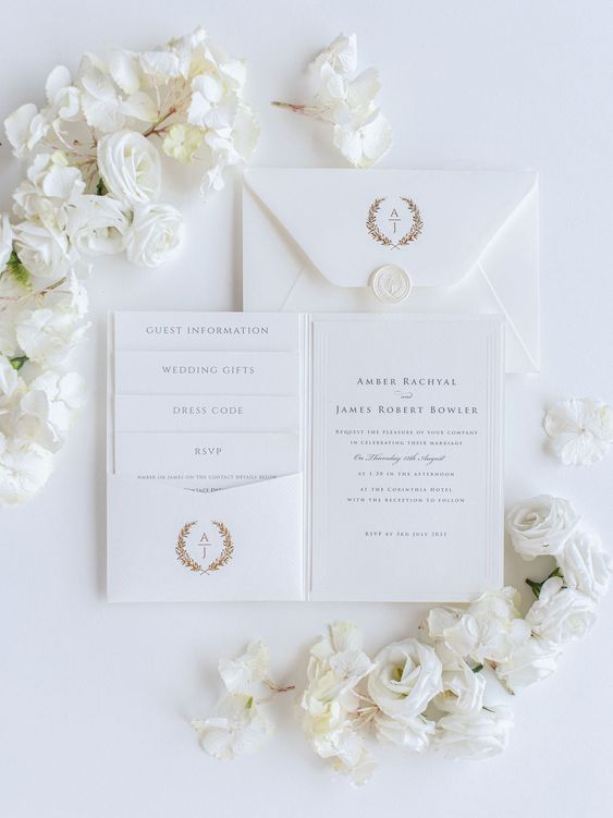 a refined white wedding invitation suite with gold letters and monograms is amazing for a glam white wedding
