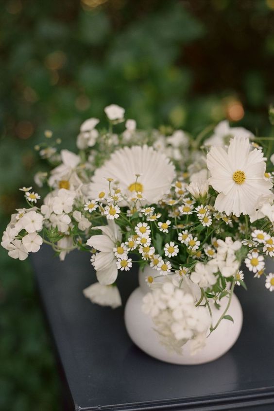 a simple and dimensional summer wedding centerpiece of cosmos, chamomiles and other fillers is a cool idea you can realize yourself