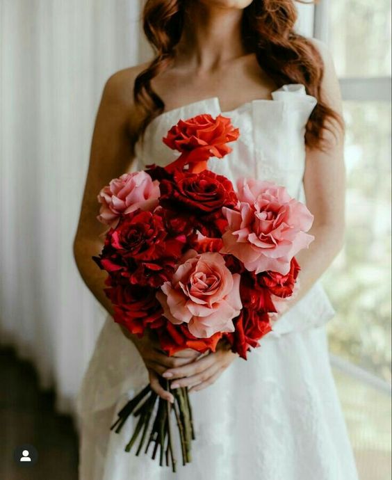 a simple yet stunning long stem wedding bouquet of pink and red roses is a great solution for a colorful wedding