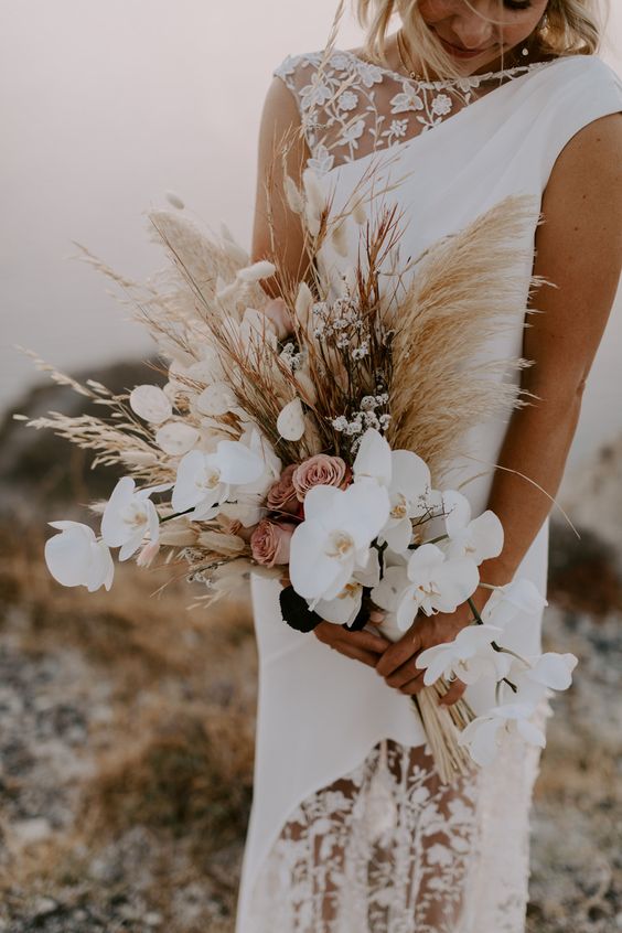 a sophisticated boho wedding bouquet of white orchids, pink roses, lunaria and pampas grass is amazing