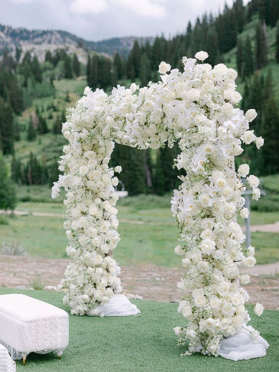 a sophisticated wedding arch done with white baby’s breath, roses and orchids is a chic and cool idea for a neutral wedding