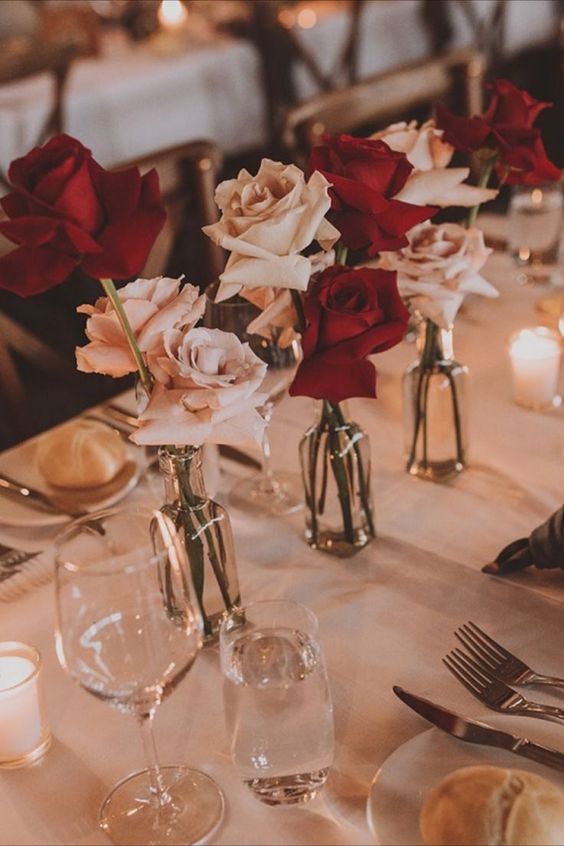 a stylish and timeless cluster wedding centerpiece of blush and red roses and candles around is amazing for a modern wedding