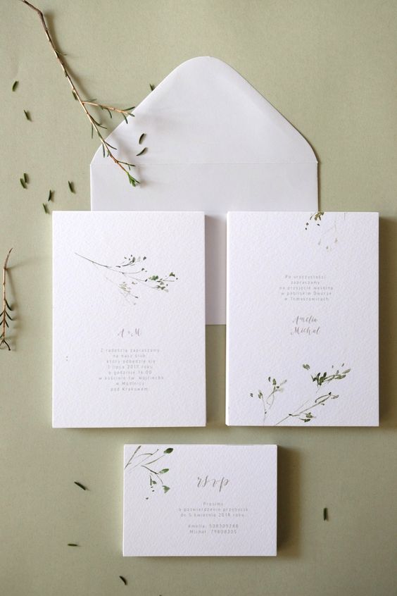 a subtle white wedding invitation suite with textured paper and handpainted greenery branches is amazing for spring