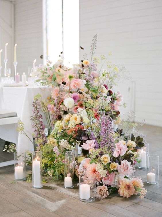 a super lush and bold cascading wedding centerpiece of pink, blush, white and yellow blooms and various foliage is wow