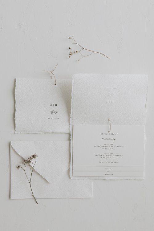 a textured white wedding invitation suite with a raw edge and black letters is a cool and catchy idea for a wedding