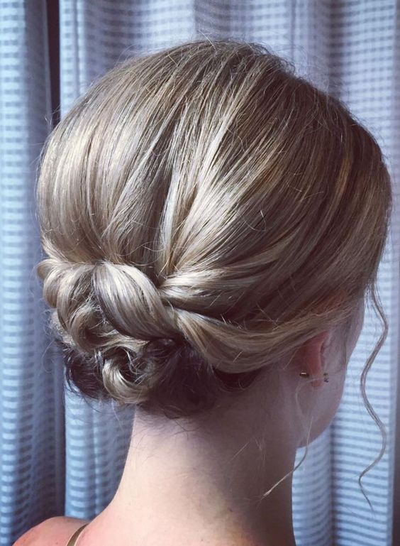 a tight wrapped low updo with a bump on top and waves framing the face is a lovely hairstyle to try for a wedding