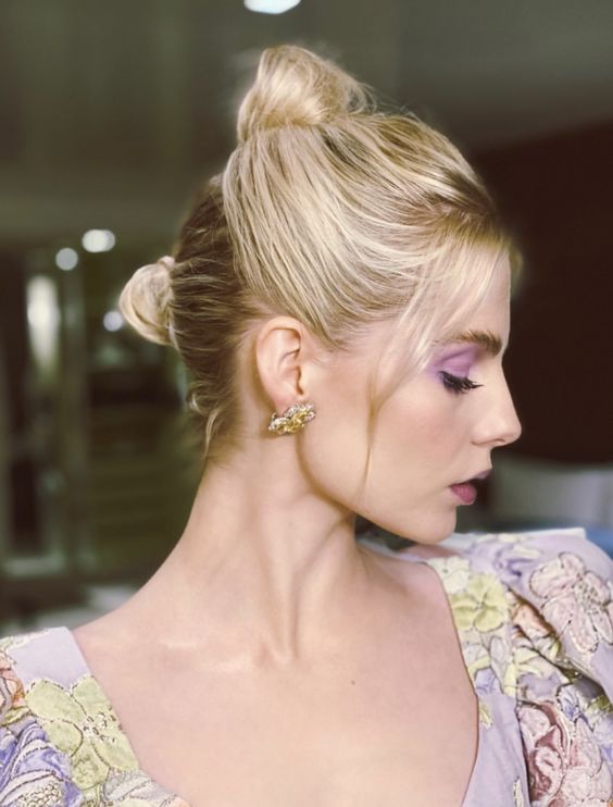 a top knot with a bump on top and face-framing hair is a cool and chic hairstyle for a wedding