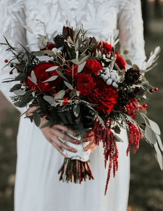 a traditional Christmas wedding bouquet of red, burgundy blooms, berries and greenery plus twigs