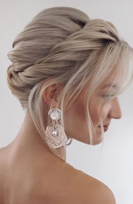 a wedding updo with a bump on top and a twisted halo plus face-framing bangs is a cool hairstyle for short hair, this way you imitate long hair