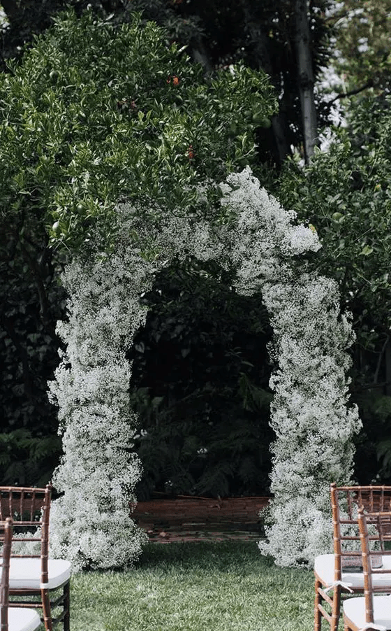 a white baby’s breath wedding arch is an elegant and chic wedding decor idea that won’t break the bank