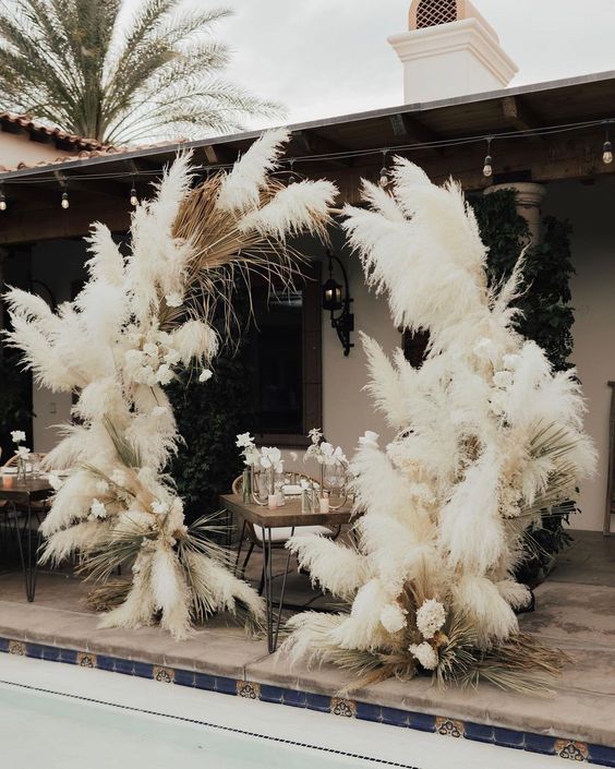 a white pampas grass wedding altar with some white blooms is a fantastic idea for a boho wedding, it looks adorable and chic