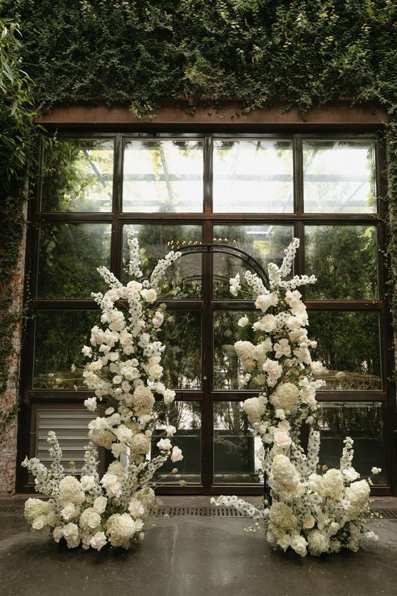 a white wedding arch of roses, hydrangeas and deliphinium is a cool idea for spring and summer