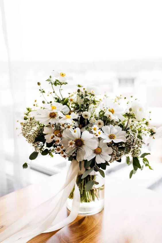 a white wedding bouquet of cosmos and chamomiles and some greenery for spring and summer is always cool