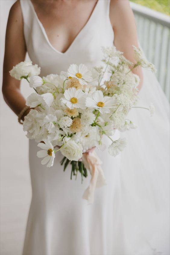 a white wedding bouquet of cosmos, roses and some fillers is a stylish idea for a modenr or minimalist bride