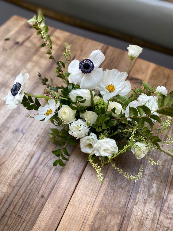 a white wedding centerpiece of cosmos, anemones and ranunculus plus greenery is a lovely idea for spring and summer