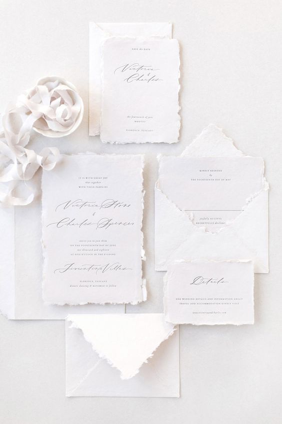 a white wedding invitation suite with a raw edge and textured paper, black calligraphy is a chic idea for an ethereal wedding