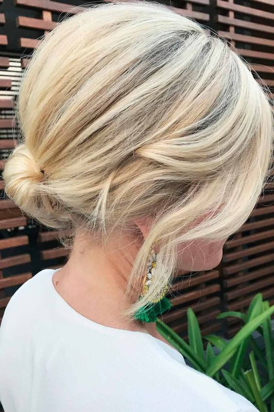 a wrapped low bun with a bump on top and face-framing hair is a chic and fast hairstyle for a wedding, great for short hair