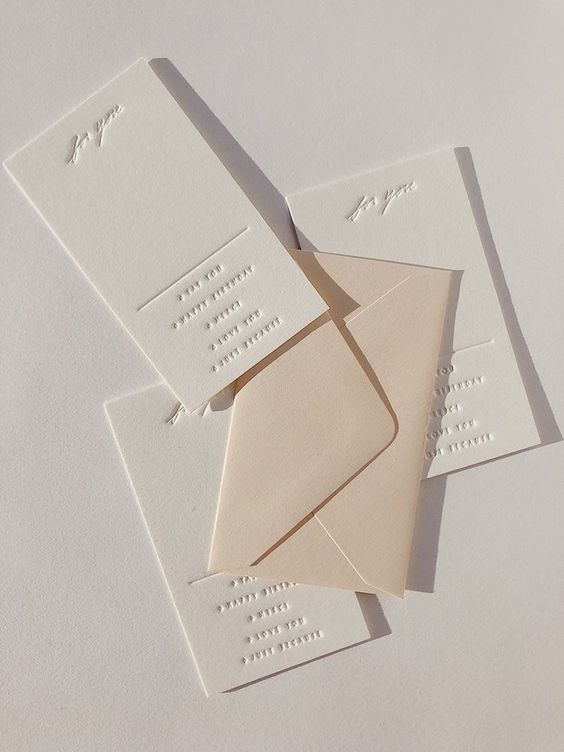 A delicate wedding invitation suite with a tan envelope and pressed letters is a chic idea for a modern neutral or all white wedding