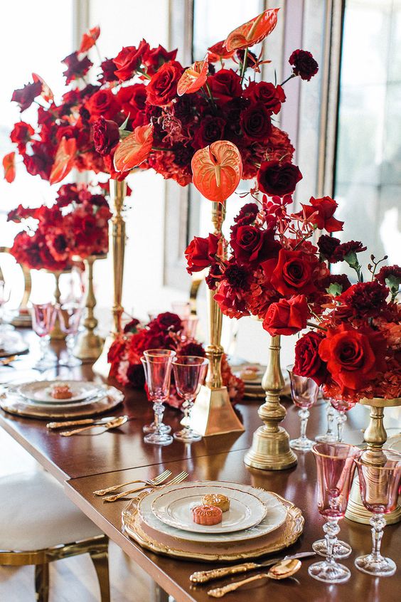 amazing tall wedding centerpieces of red and burgundy roses and orange anhturiums are perfect for a bold and exquisite wedding