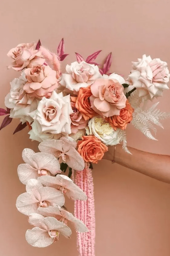 an adorable wedding bouquet with white, blush and orange roses, blush orchids and pink amaranthus is amazing