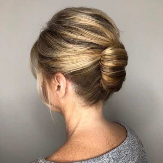 an elegant French chignon with a bump on top and face-framing hair is a cool and classy wedding hairstyle for short hair