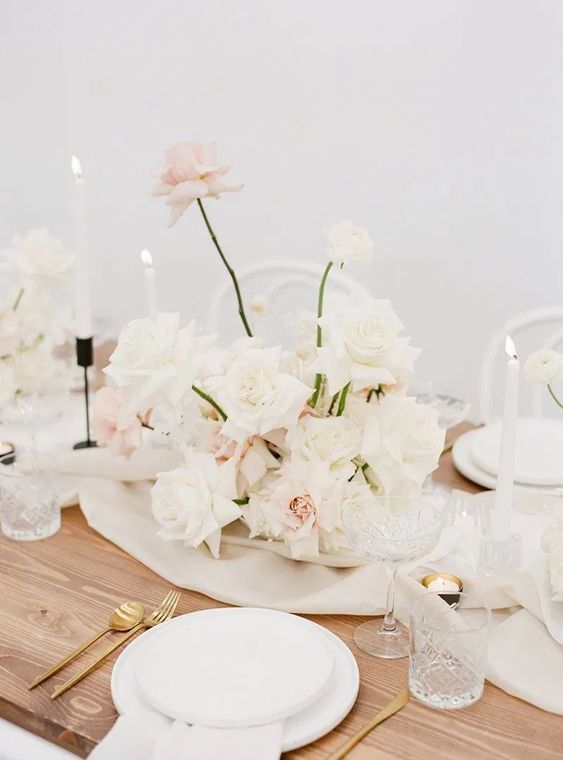an elegant modern wedding centerpiece of blush and white roses is a stunning decor idea for a neutral wedding