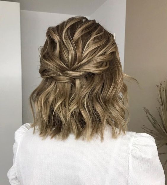 an elegant wavy half updo with a wavy bump, a twisted halo and waves id a cool idea for wavy hair