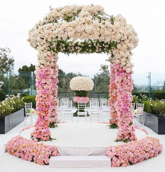 an ombre wedding arch from pink to blush, with greenery, is a lovely idea for a spring or summer wedding