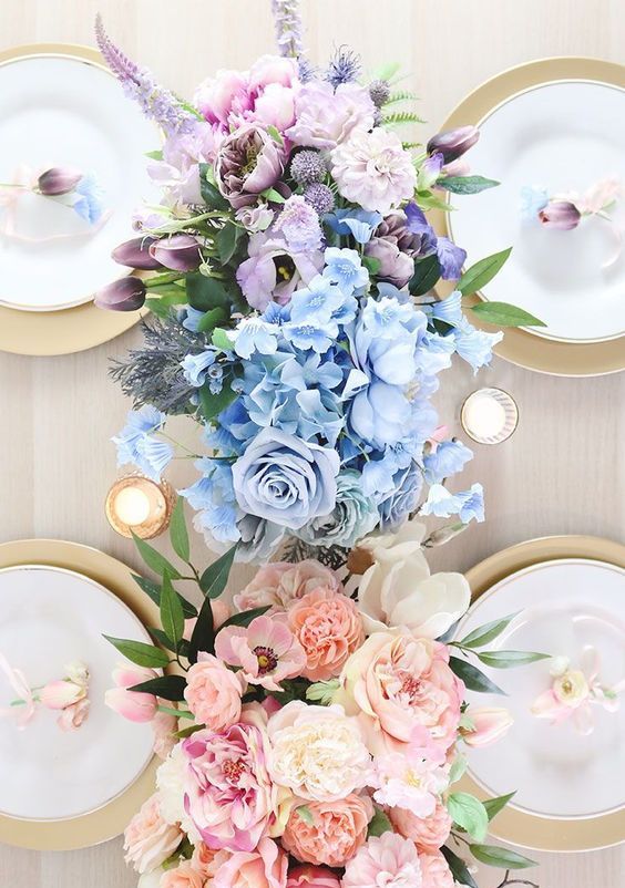 an ombre wedding centerpiece from pink to blue and lilac, with roses, peonies and astilbe is wow for a spring or summer wedding