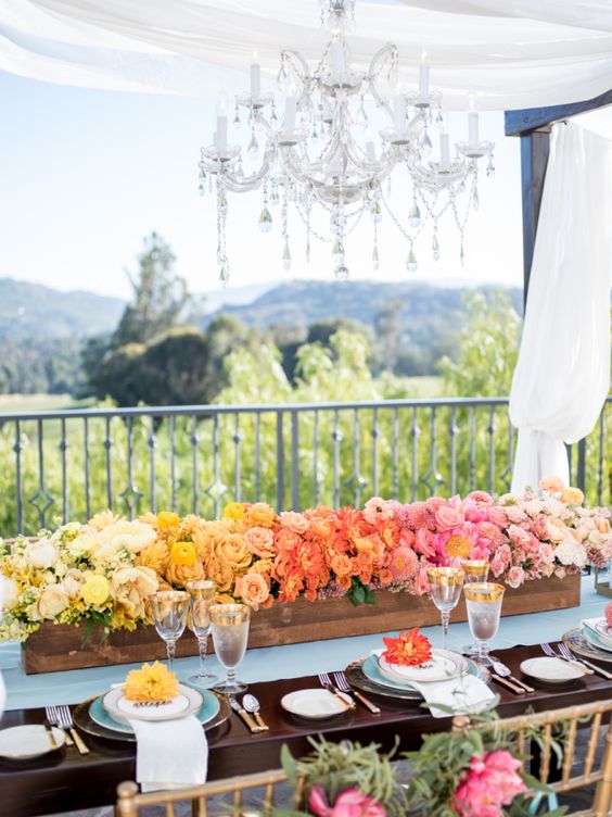 an ombre wedding centerpiece from yellow to bold yellow, coral and pink is amazing for a bright summer wedding