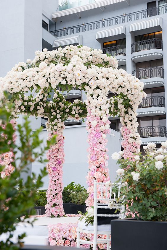 an ombre wedding chuppah from light pink to blush and greenery is a cool and eye-catchy decoration for a spring or summer wedding