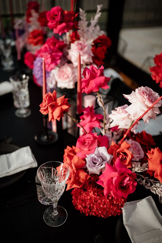 chic and bold modern wedding centerpieces composed of only red, orange, blush and lilac roses and matching candles for a modern wedding
