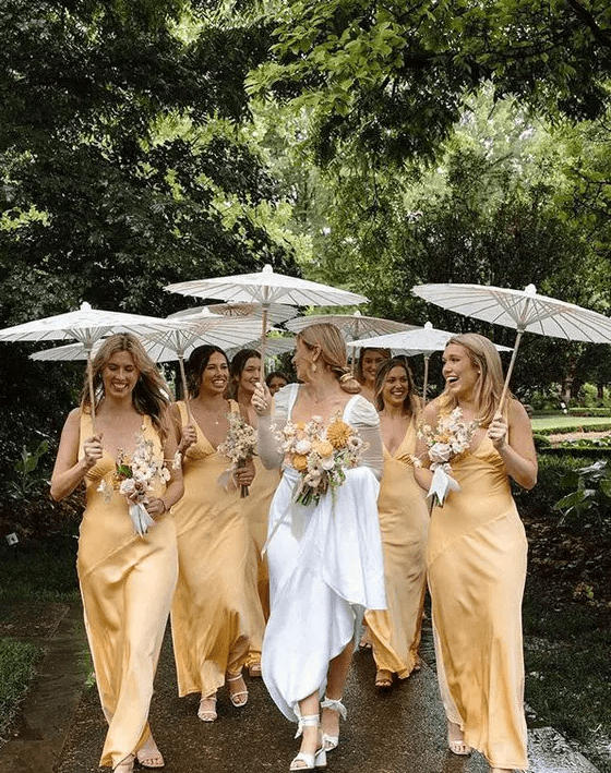 Classy yellow satin maxi bridesmaid dresses with straps and V necklines plus white shoes for a summer wedding