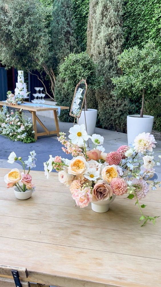 a pretty summer wedding centerpiece of white cosmos, blush dahlias, mums and roses and some fillers is a cool and lovely solution
