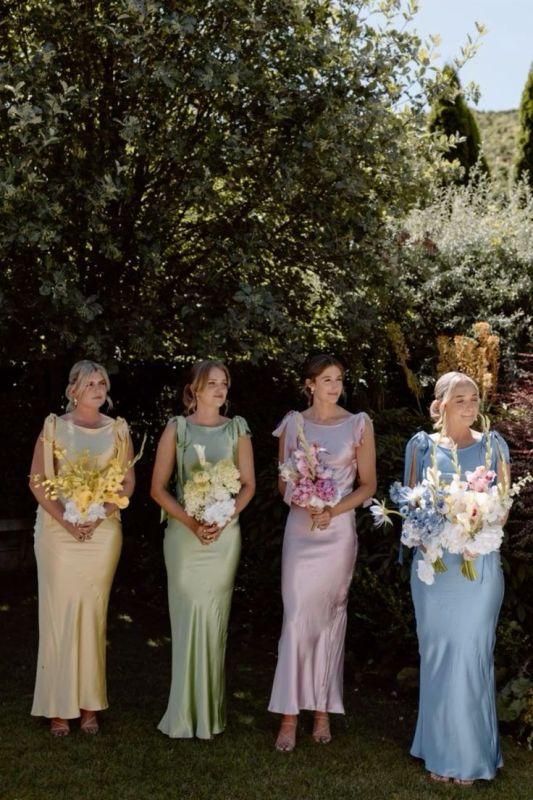 matching pastel maxi bridesmaid dresses  with bows on the shoulders are adorable for a pastel spring or summer wedding
