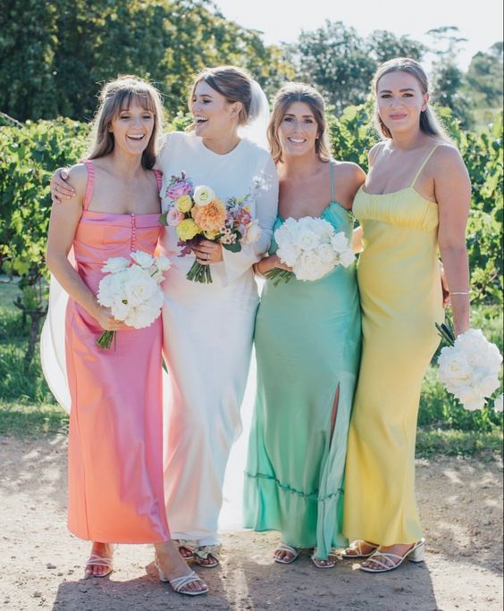 mismatching maxi pastel bridesmaid dresses, matching white shoes and white bouquets for a pastel-colored spring wedding