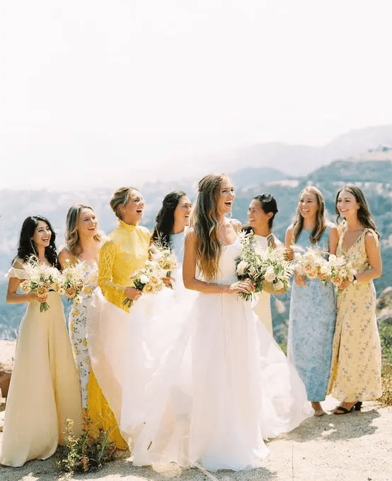 Mismatching pastel blue and yellow printed and non printed bridesmaid dresses of maxi length are adorable