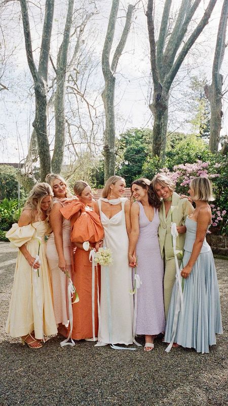 mismatching pastel maxi bridesmaid dresses in yellow, green, lilac, blue and orange are perfect for spring