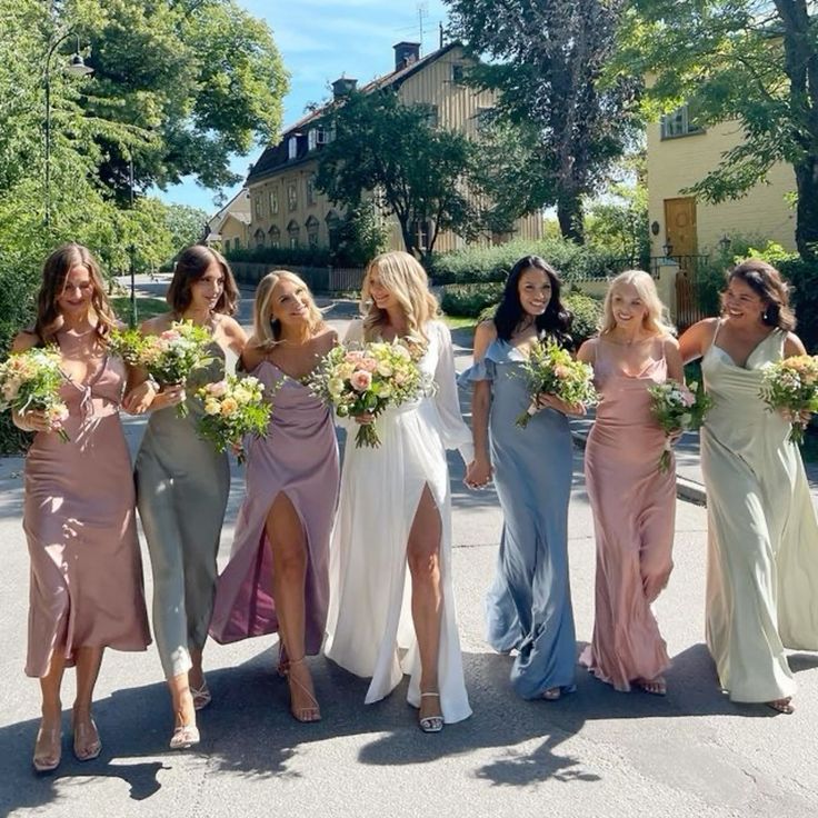 mismatching pastel sating maxi and midi bridesmaid dresses are always a good idea for a spring or summer wedding