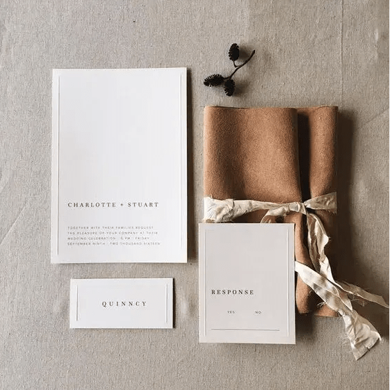 Neutral wedding invitations wrapped with faux leather to add an eye catchy touch
