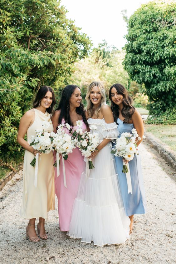 stylish pastel midi bridesmaid dresses in yellow, pink and blue are a cool solution for a spring or summer wedding