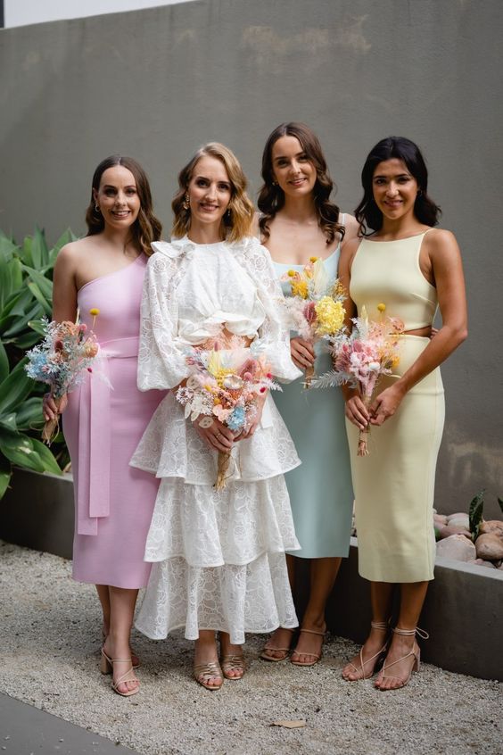 stylish pastel midi bridesmaid dresses with mismatchign designs and lace up shoes are amazing for a spring wedding