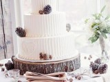 a white textural woodland wedding cake decorated with pinecones and acorns, with squirrel toppers is a very cool idea