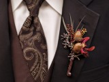 a bright fall boutonniere  of acorns, greenery, berries and a single red bloom is a lovely idea to accent a fall groom or groomsman look