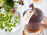 a wooden acorn with a table number is a creative idea for a fall wedding, it’s rustic chic for your tablescape