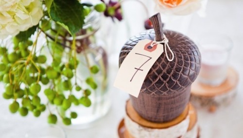 a wooden acorn with a table number is a creative idea for a fall wedding, it's rustic chic for your tablescape